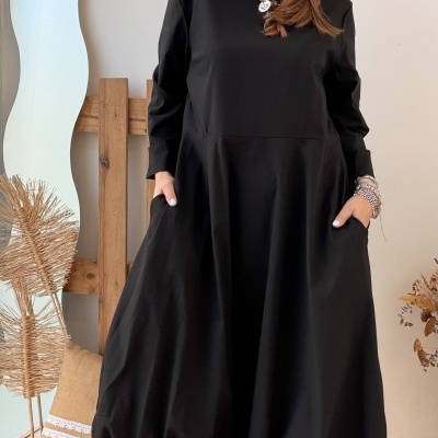 Vestido preto comprido com mangas e saia ampla e botas castanhas