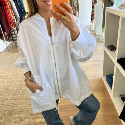 Blusão branco com fecho de correr em ambiente de loja