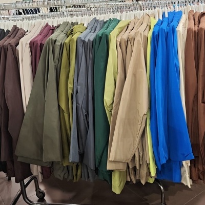 Várias roupas coloridas penduradas em cabide na loja