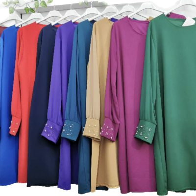 Vestidos de manga comprida com punhos decorados pendurados em cabides