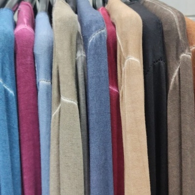 Várias camisolas de malha coloridas penduradas em varão