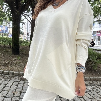 Mulher com blusão e calças brancas de malha ao ar livre