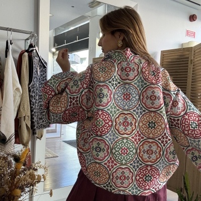 Casaco colorido padrão geométrico usado por mulher vista de costas