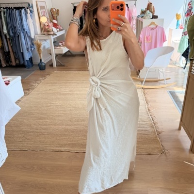 Mulher a usar vestido branco com nó lateral em loja de roupa
