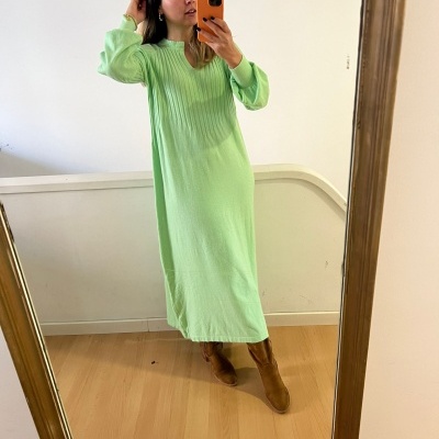 Vestido verde claro comprido com mangas compridas em tecido canelado e liso, mulher a tirar selfie num espelho grande