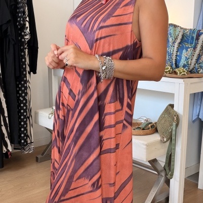 Vestido sem mangas laranja e roxo com padrão abstrato em ambiente interior