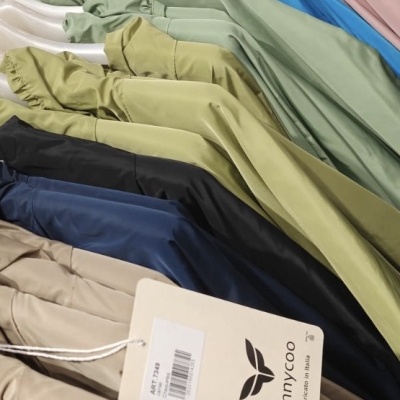 Casacos coloridos pendurados numa arara com etiqueta de marca