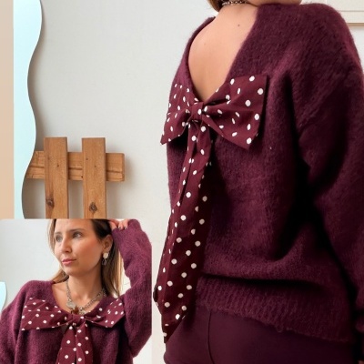 Mulher veste camisola vinho felpuda com laço de bolinhas brancas e calças vinho.
