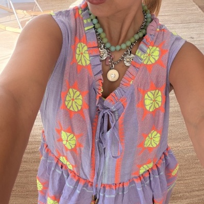 Vestido bordado lilás com laço frontal e colares verdes e prateados