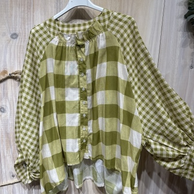 Blusa de manga comprida xadrez verde e branco num cabide branco