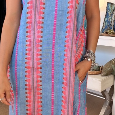 Vestido azul com padrões verticais cor-de-rosa e laranja e acessórios de metal