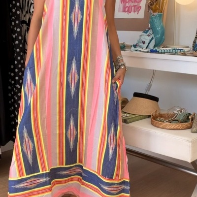 Vestido comprido colorido com padrões geométricos e sandálias brancas