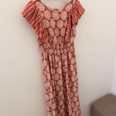 Vestido com padrão de conchas e riscas em tons de laranja e rosa