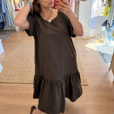 Vestido preto feminino de tecido leve com saia franzida numa loja de roupa