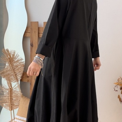 Vestido longo preto com mangas compridas e botas castanhas