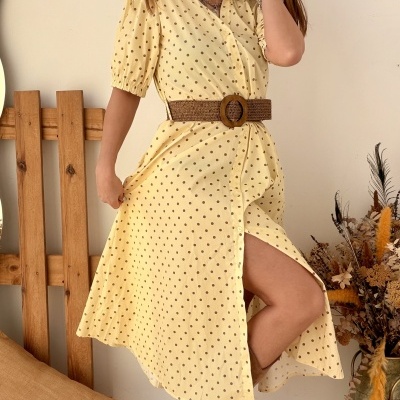 Vestido amarelo de bolinhas com cinto castanho e botas de camurça castanhas