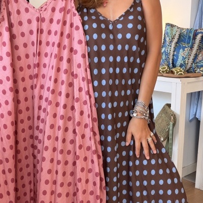 Mulher com vestidos às bolinhas em loja