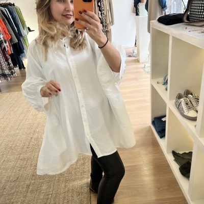 Camisa branca larga de algodão com botões frontais usada por mulher a tirar selfie