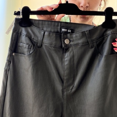 Calças pretas imitação couro penduradas em cabide preto com etiqueta WSY G8