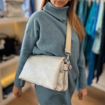 Bolsa de ombro bege claro de couro sintético com mulher vestindo vestido azul clara