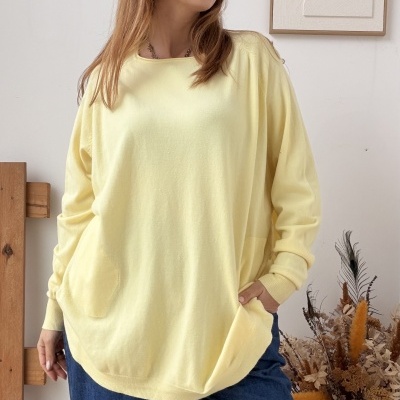 Mulher com camisola amarela e calças azuis no interior com decoração simples