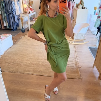 Vestido verde curto com nó lateral em loja de roupa