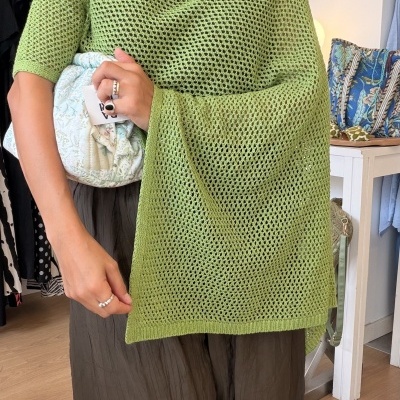 Mulher vestindo xale verde claro de malha com padrão aberto