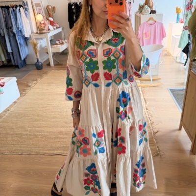 Vestido bordado colorido comprido com gola e mangas compridas numa loja de roupa