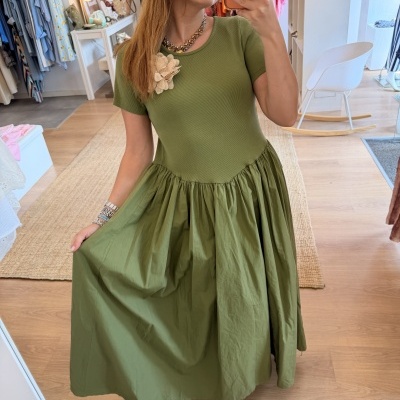 Vestido verde com flor de tecido bege no ombro e saia franzida