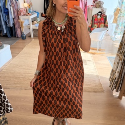 Vestido castanho com manchas pretas e gola franzida em loja de roupa