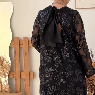 Vestido preto transparente com padrões florais bordados em preto e laço na parte de trás do pescoço