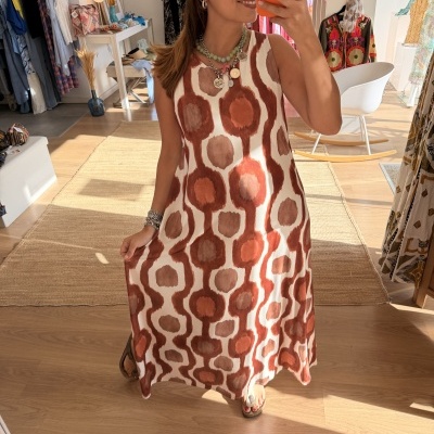 Vestido midi com padrão geométrico em cores terra num espelho numa loja.