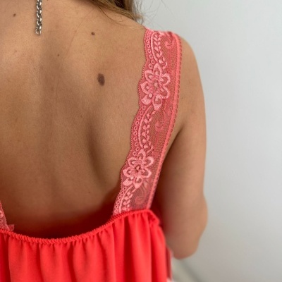 Vestido ou blusa com alças de renda floral cor rosa claro num fundo branco