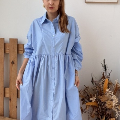 Vestido azul claro comprido com botões usado por mulher