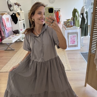 Vestido cinzento com capuz e folhos numa loja de roupa