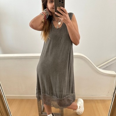 Vestido midi cinza com renda na bainha e ténis brancos em ambiente interior.