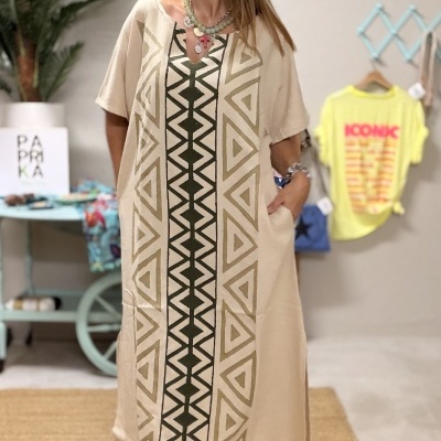 Vestido comprido bege com padrão geométrico verde e camel e sandálias pretas