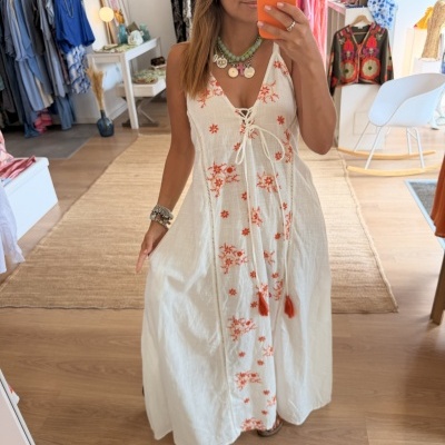 Vestido longo branco bordado com flores laranja, decote em V e laço na frente