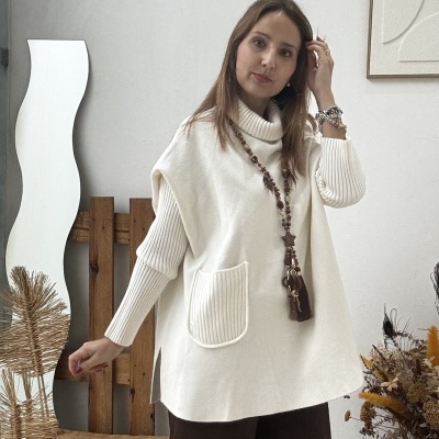 Mulher com camisola oversized branca e calças largas castanhas