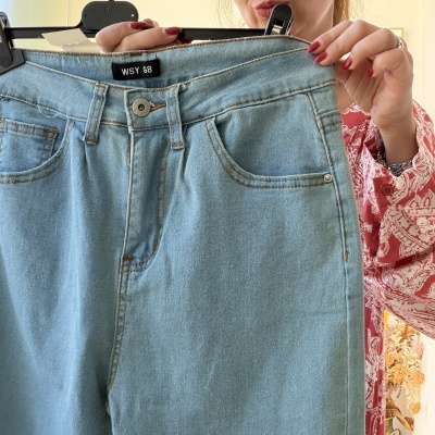 Calças de ganga azuis claras com etiqueta WSY G8 a serem mostradas por mulher