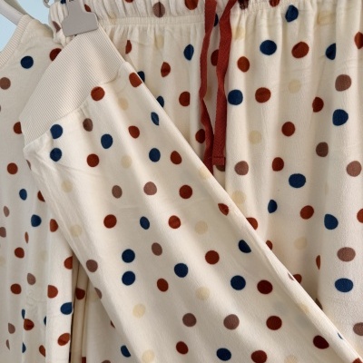 Conjunto de pijama creme com bolinhas azuis, castanhas e bege.