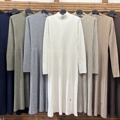 Vestidos compridos de malha com gola alta e saia plissada em várias cores pendurados