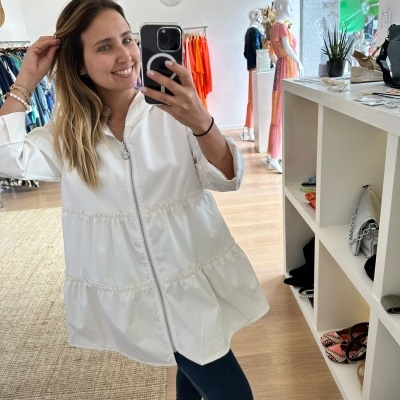 Casaco branco com fecho de correr prateado numa loja de roupa