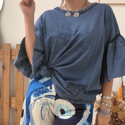 Pessoa com blusa azul e saia estampada abstrata azul e branca