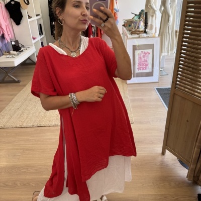 Mulher a tirar selfie com vestido vermelho e saia branca em loja de roupa