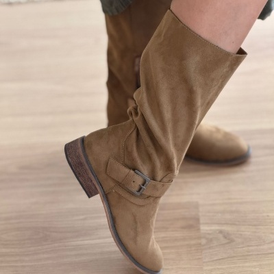 Bota camurça caramelo com fivela e salto baixo em piso madeira