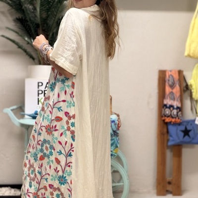 Vestido comprido branco com padrão floral colorido em mulher de costas