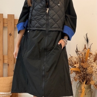 Vestido preto acolchoado com fecho e mangas azuis usado por mulher em ambiente interior