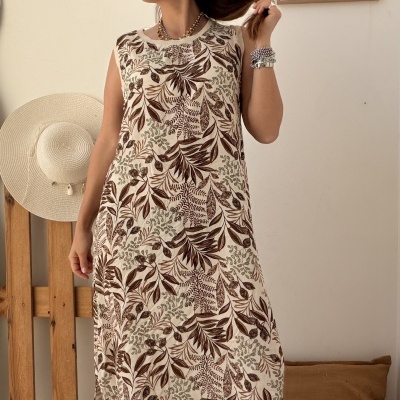 Vestido longo com padrão de folhas castanhas e verdes em fundo creme
