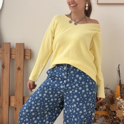 Mulher com camisola amarela, calças azuis de bolinhas e ténis com glitter